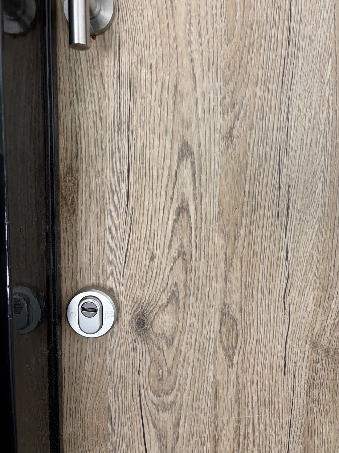 Afzonderlijke ronde SKG-gecertificeerde kerntrekrozet op een houten deur