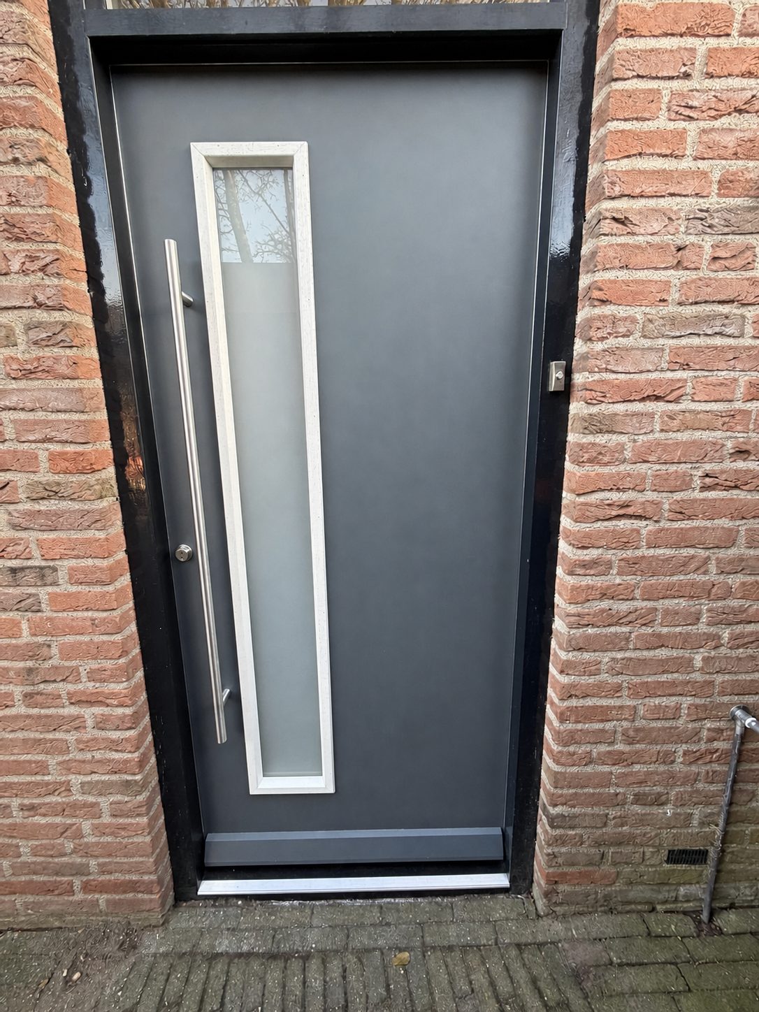 Moderne voordeur met glasstrook, RVS deurbeslag en weldorpel aan de onderzijde